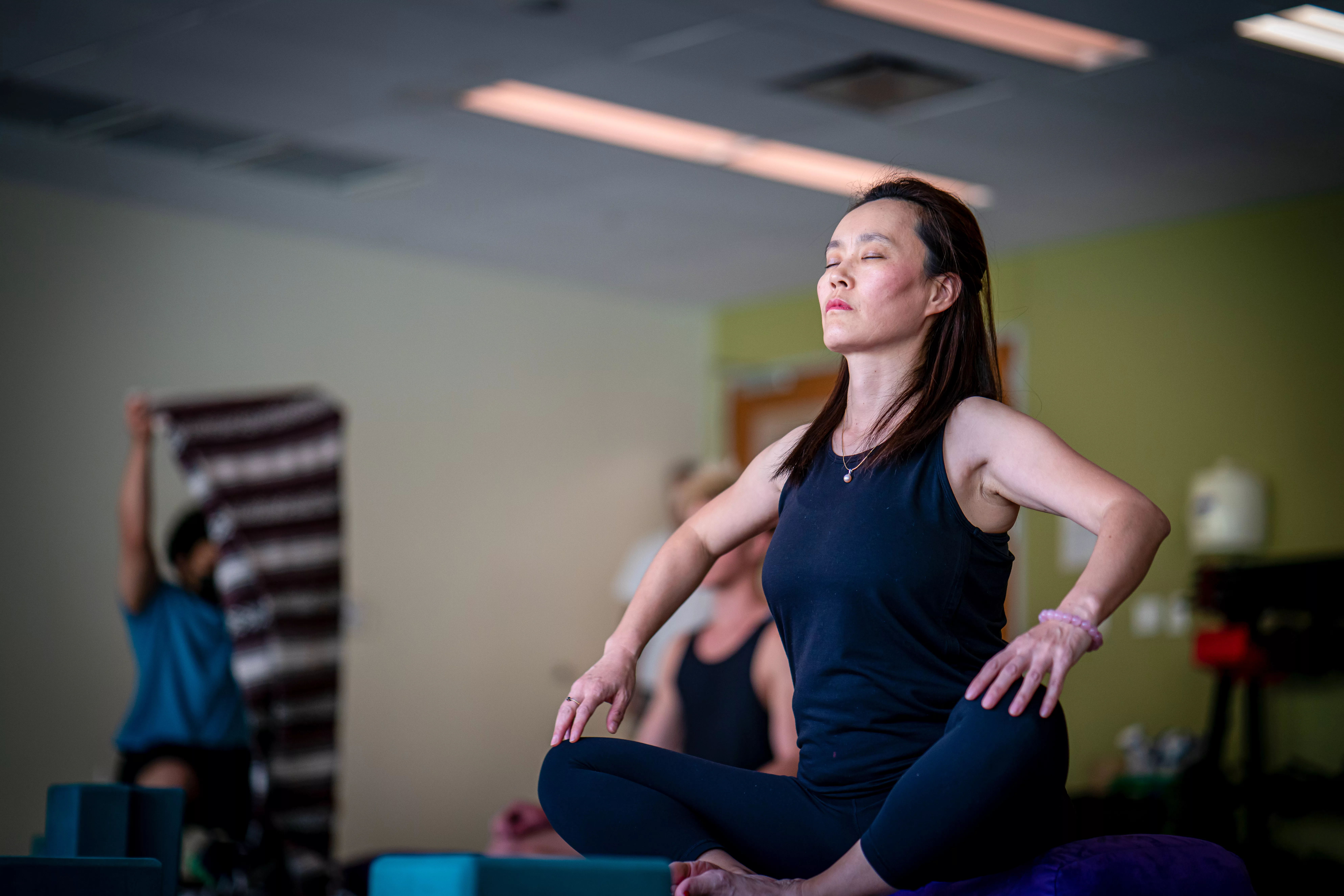 yoga-meditation-header A woman sits cross legged with her arms on her knees and eyes closed