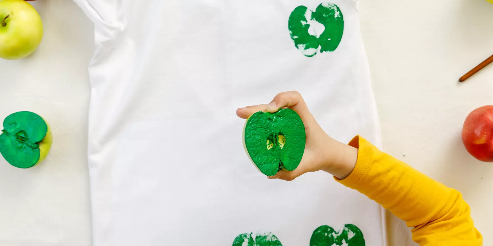 an apple is cut in half and painted to act as a stamp for a craft activity