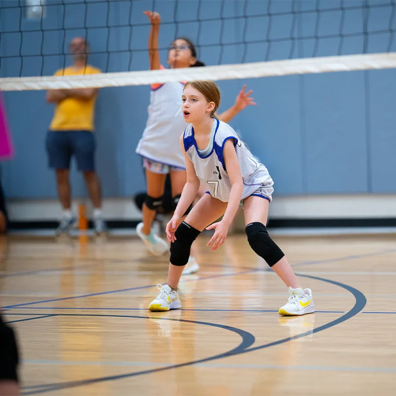 children play a game of youth volleyball