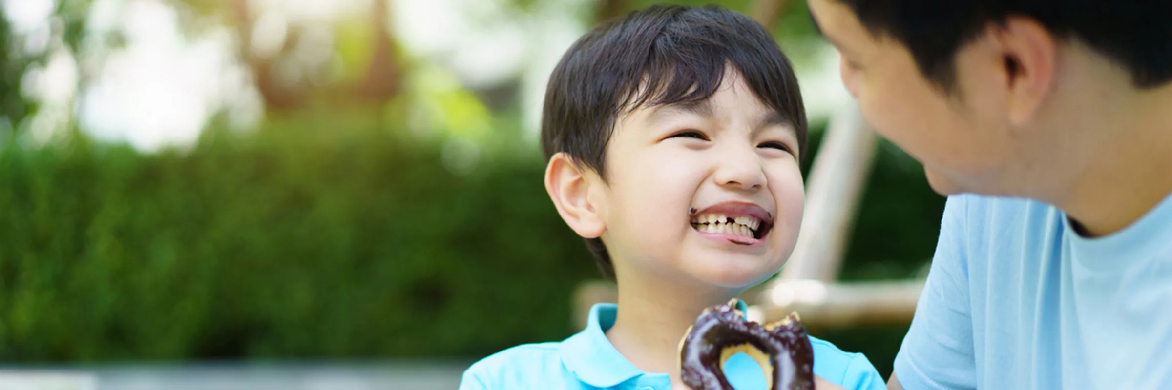 A father and child eat donuts together