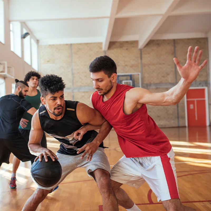 men scrimmage in an adult basketball game