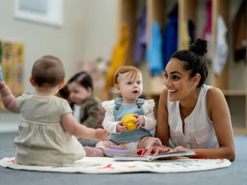 tomorrow-acadamy-baby-toddler-child-2-horizontal-overview a woman lies on a floor playing with babies