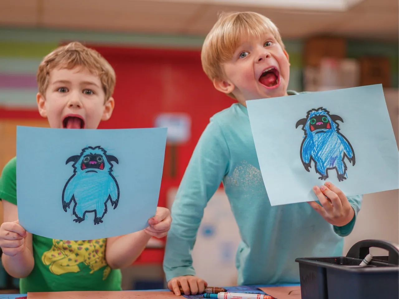 Two boys with excited expressions show off their winter artwork