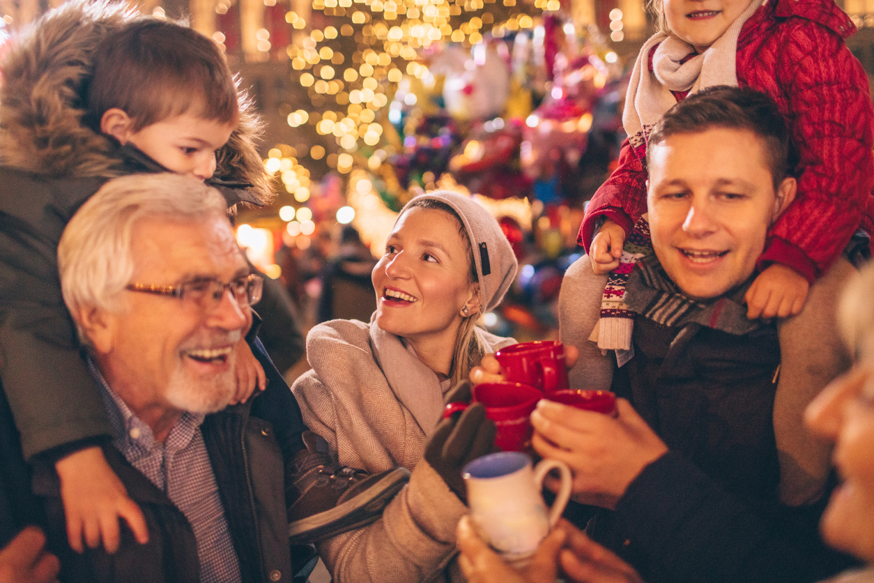 A family of various ages smile and laugh in a holiday backdrop