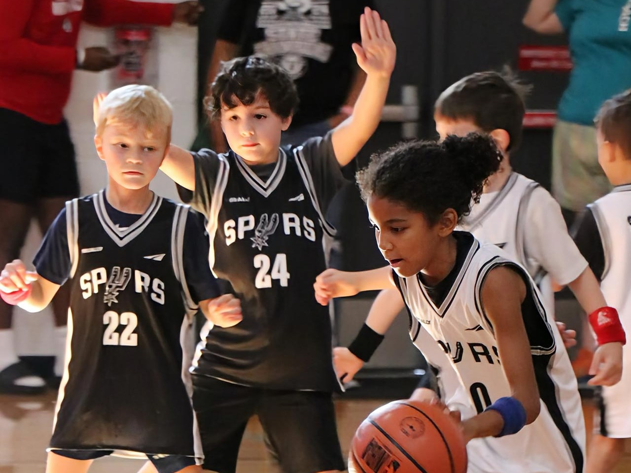 youth-basketball-spurs Kids in Spurs jerseys play youth basketball at the Greater Austin YMCA, building teamwork and confidence on the court.