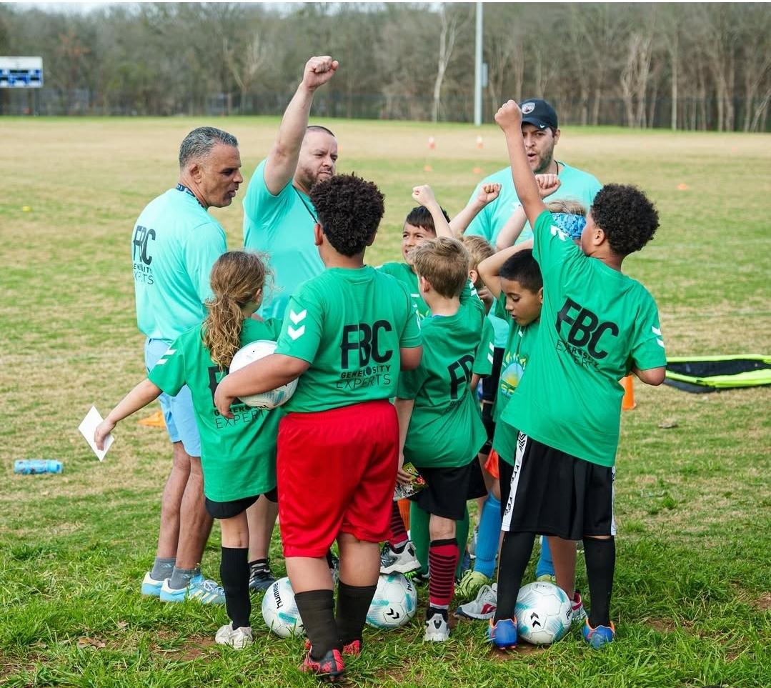 Players and coaches cheer together on the field in matching green jerseys