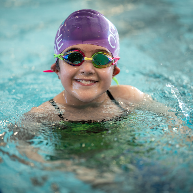 A child in a pool practices swimming stamina.