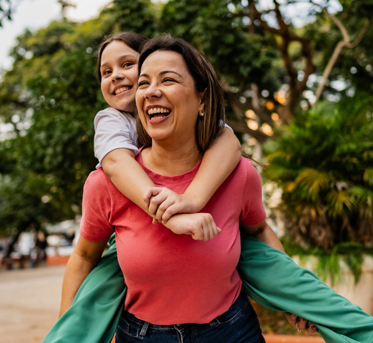 Mother and daughter doing piggyback outdoors