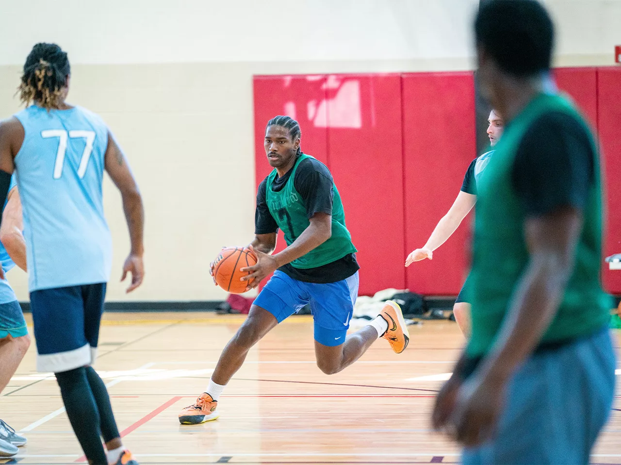 An adult basketball player navigates the court with the ball.