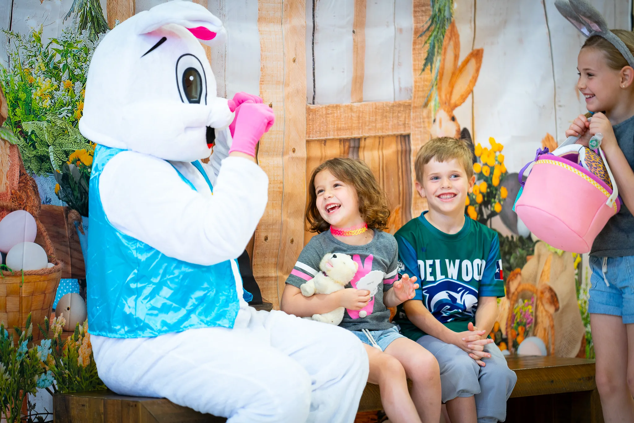3 kids laugh while talking with the Easter Bunny