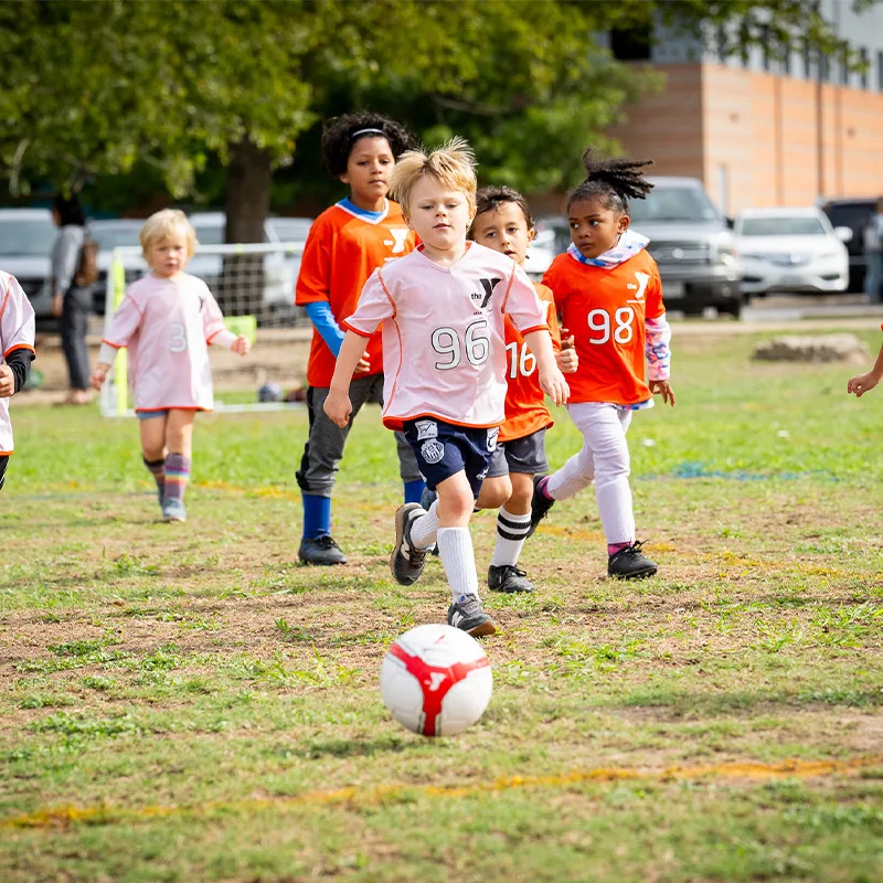 Children play soccer outdoors.