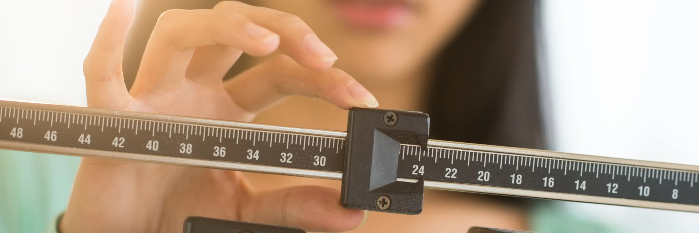 a sliding scale is shown with someone in soft focus adjusting the weight slider.